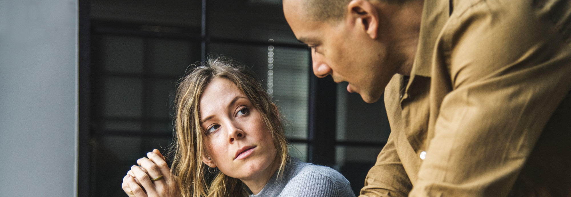 A woman and man are in conversation, looking at each other.